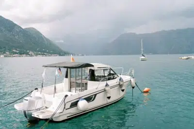 Motor yacht moored off the coast against the background of mountains in the fog