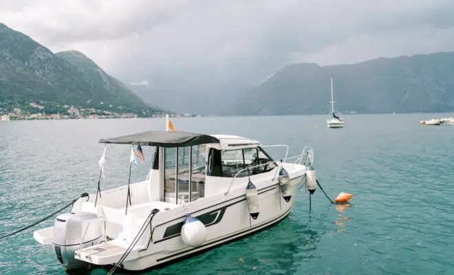 Motor yacht moored off the coast against the background of mountains in the fog