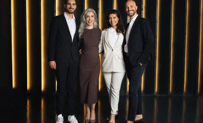 Business Team Of Four Colleagues Standing In Dark Luxury Office