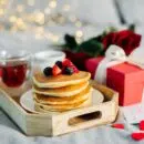 Mother's Morning breakfast on wooden tray with greeting card I love you mom, bouquqet of red roses