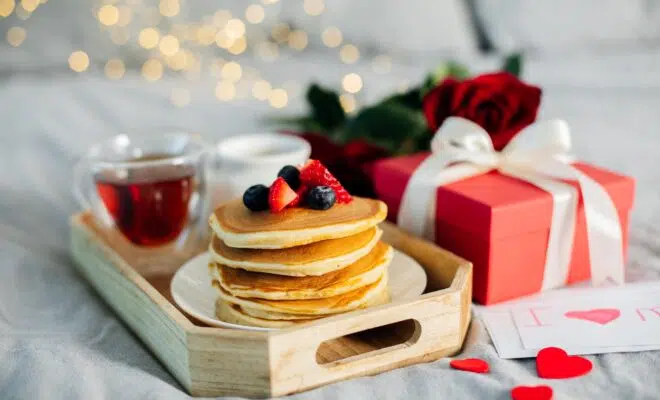 Mother's Morning breakfast on wooden tray with greeting card I love you mom, bouquqet of red roses