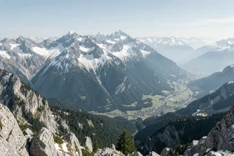 Vue aérienne panoramique des massifs des Alpes françaises avec sommets enneigés et vallées boisées